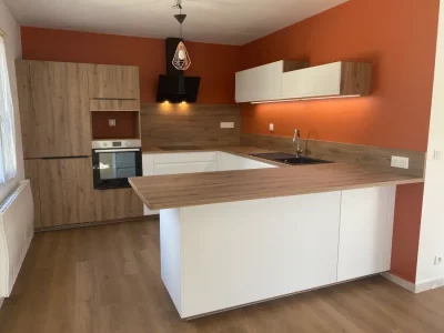 Cuisine sur mesure avec un mélange d'éléments en bois et blanc, offrant une esthétique moderne et chaleureuse. L'association du bois naturel avec le blanc crée un contraste subtil et équilibré par L. Cuisine et Aménagement