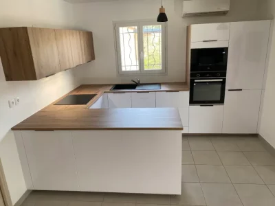 Cuisine sur mesure blanche avec un plan de travail en bois, offrant une esthétique moderne et chaleureuse par L. Cuisine et Aménagement sur Nîmes et Montpellier.
