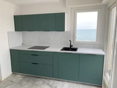 Création d'une cuisine vert-turquoise avec un plan de travail marbré, offrant une esthétique colorée et sophistiquée. Malgré sa taille réduite, cette cuisine apporte une touche de fraîcheur et d'élégance grâce à son choix de couleurs vibrantes et de matériaux luxueux par L. Cuisine et Aménagement