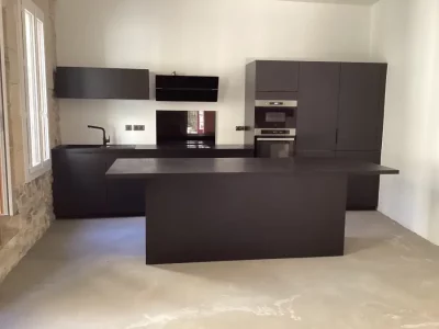 Cuisine sur mesure entièrement noire avec électroménager assorti, offrant une esthétique moderne et sophistiquée. Le design monochrome crée une ambiance élégante et intemporelle, mettant en valeur le contraste et la simplicité des lignes