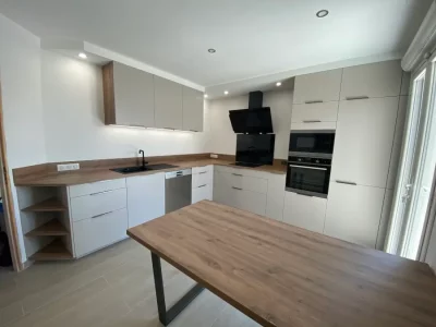 Cuisine blanche fonctionnelle avec de nombreux rangements, offrant à la fois style et praticité. Les nombreuses solutions de rangement intégrées permettent d'optimiser l'espace et de maintenir une esthétique épurée par L. Cuisine et Aménagement