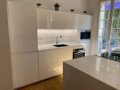 Petite cuisine sur mesure blanche, offrant une esthétique lumineuse et moderne malgré sa taille réduite. La palette blanche crée une sensation d'espace et de luminosité, idéale pour les espaces compacts créée par L. Cuisine et Aménagement.